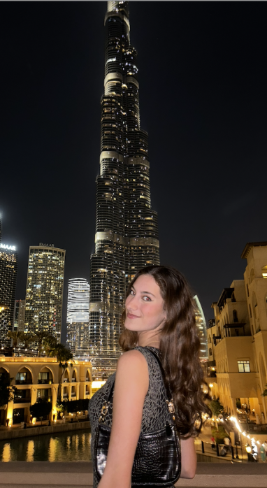Maya Makarovsky posing with the Burj Khalifa in Dubai, UAE, at night